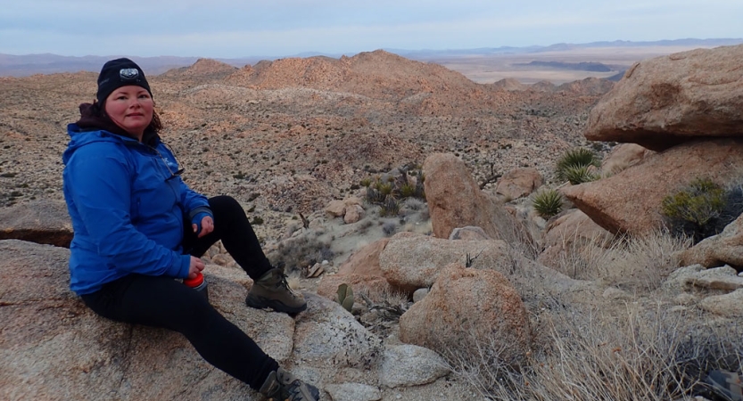 a veteran poses for a photo in front of the vast desert landscape of joshua tree national park